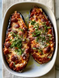 Top-down view of roasted eggplant boats overflowing with marinara and melted mozzarella. (stuffed eggplant parmesan)