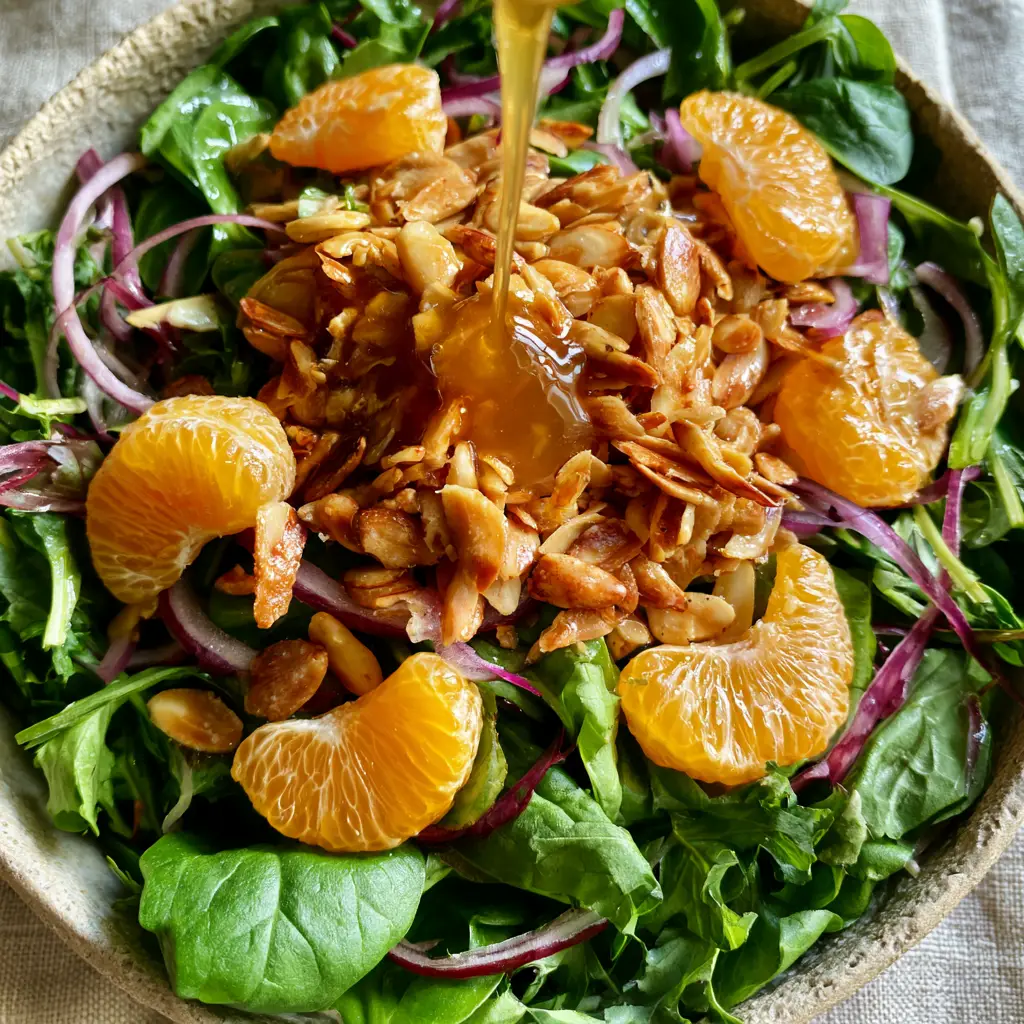 Macro shot of juicy mandarin orange segments and toasted almonds on a bed of spinach. (mandarin orange salad)