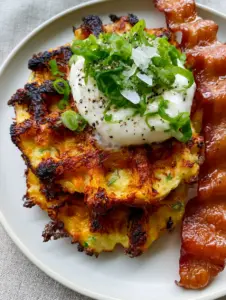 Top-down view of thick mashed potato waffles with visible chives and melted cheese threads. (potato waffle recipe)