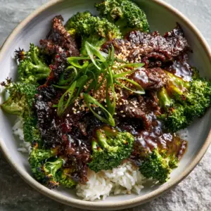 Close up of seared flank steak and emerald green broccoli florets in a mahogany sauce. (beef and broccoli)